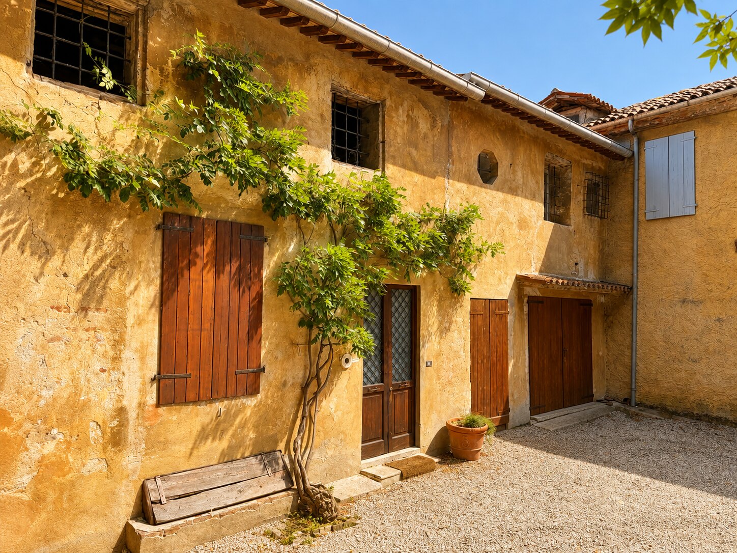 Cortile di Villa Giolai con ingresso rustico, panca in legno e rampicante