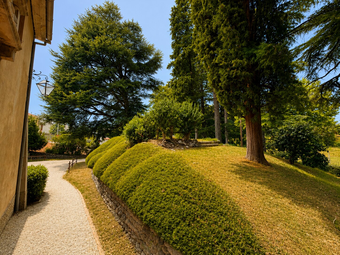 Sentiero in ghiaia e terrazzamento con siepi nel parco di Villa Giolai
